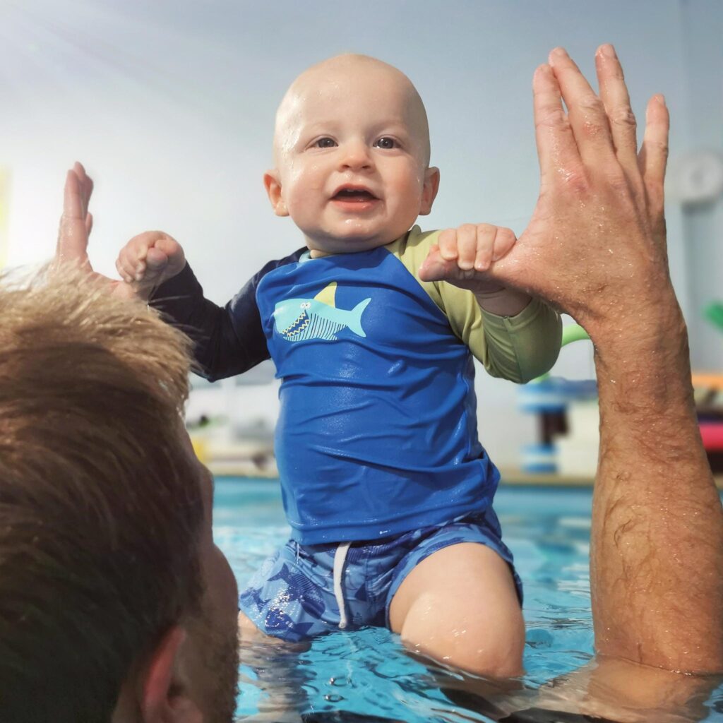 Baby enjoying early swimming lessons to promote water safety and confidence.